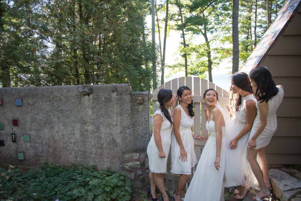 bride and bridesmaids hiding before ceremony at traverse city vineyard wedding