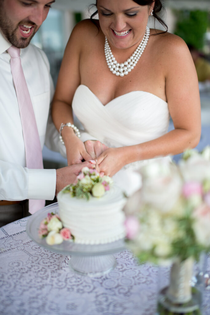 bride and groom candid cutting cake at wedding in traverse city michigan