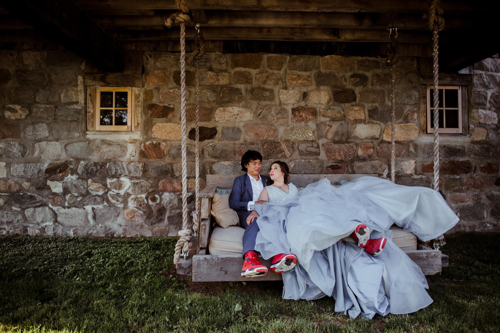 bride and groom laying on swing at starry night barn in suttons bay michigan