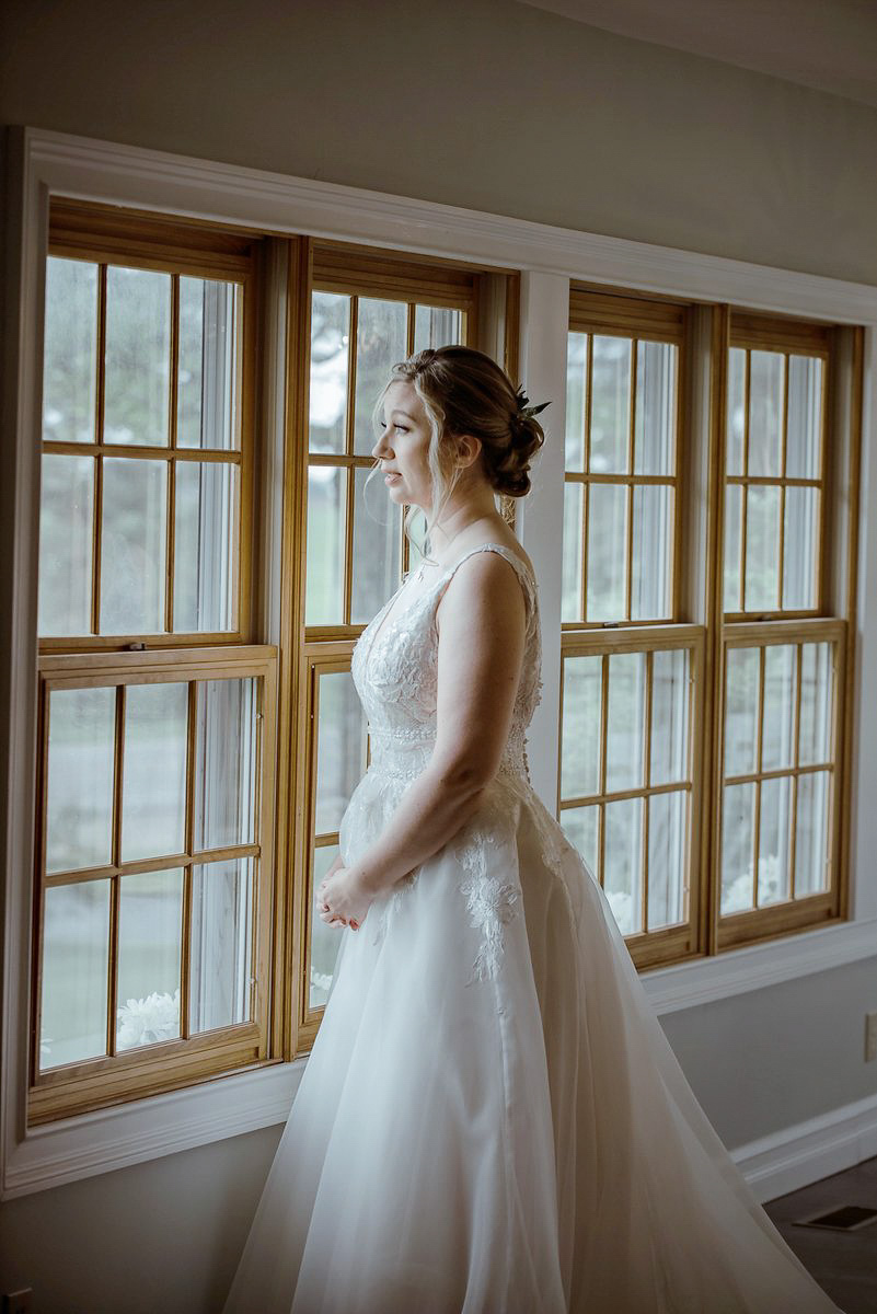 Traverse-City-Michigan-Wedding-Photographer-95 bride looking out window crying during traverse city wedding
