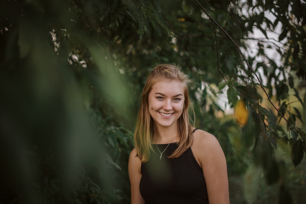 high school senior in trees during senior pictures in traverse city photographer