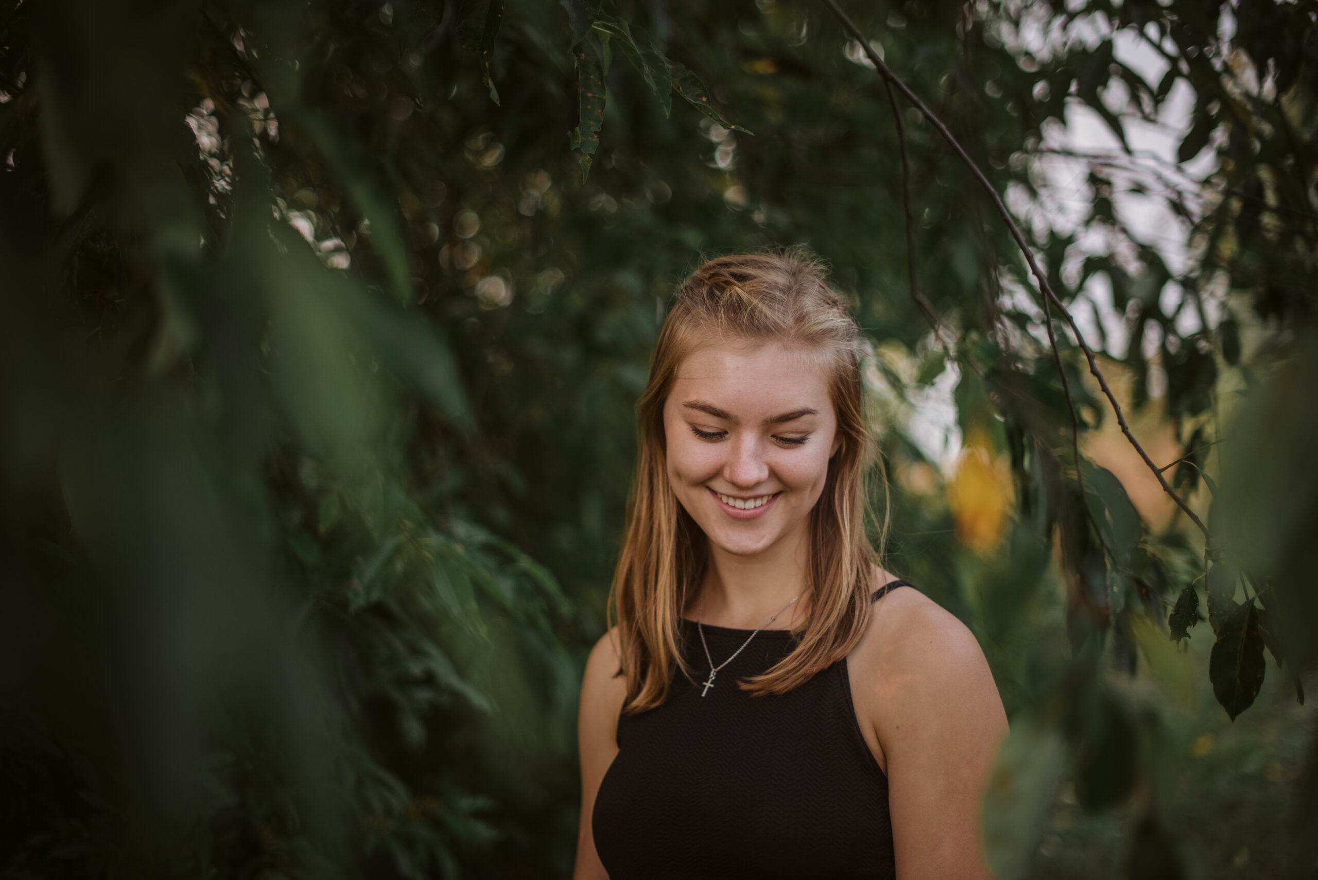 high school senior in trees during senior pictures in traverse city photographer