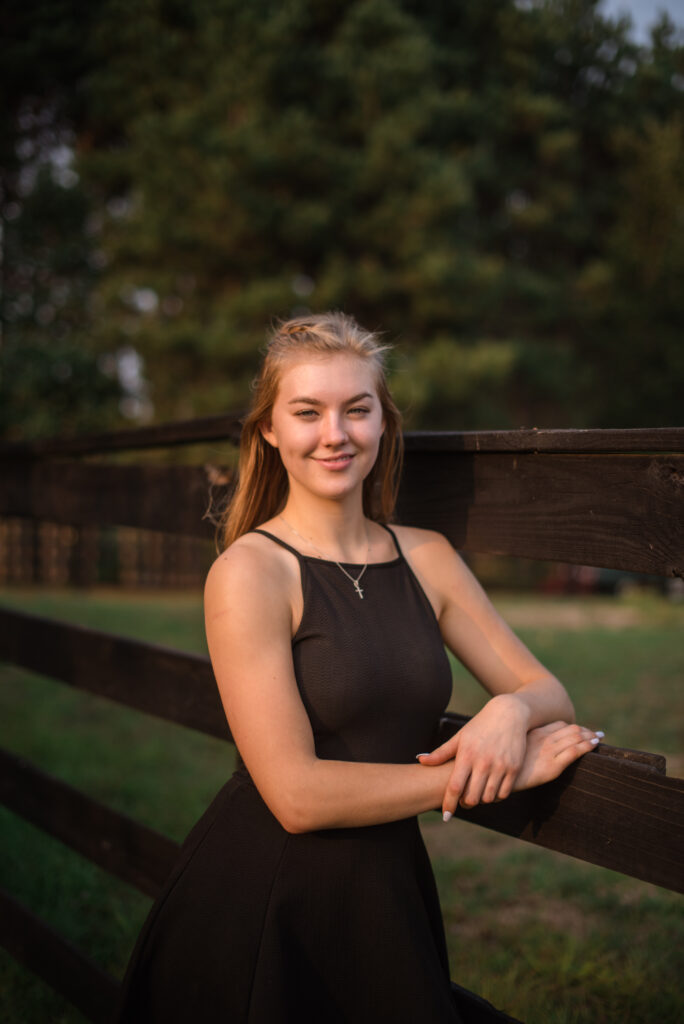 Grand Traverse Academy Senior standing in field sunset during senior photos in traverse city