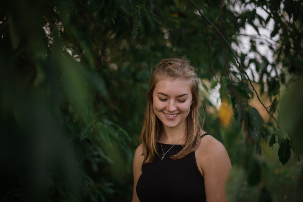Grand Traverse Academy Senior standing in field sunset during senior pictures in traverse city