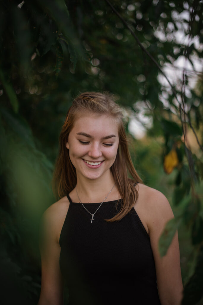 Grand Traverse Academy Senior standing under willow tree during senior pictures in traverse city