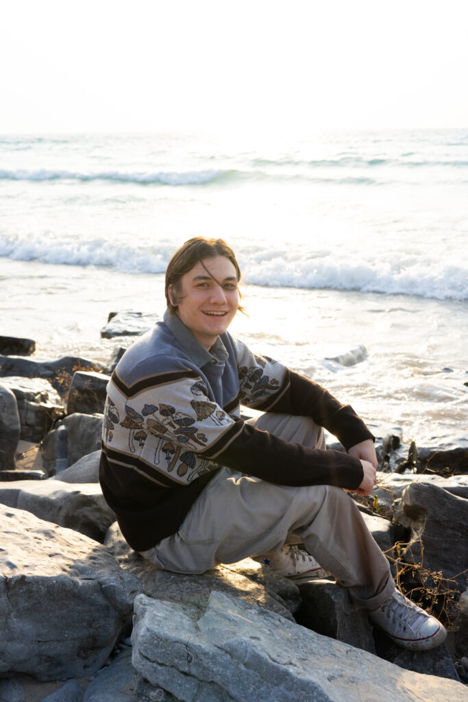 senior photo of boy laughing candid on empire michigan beach