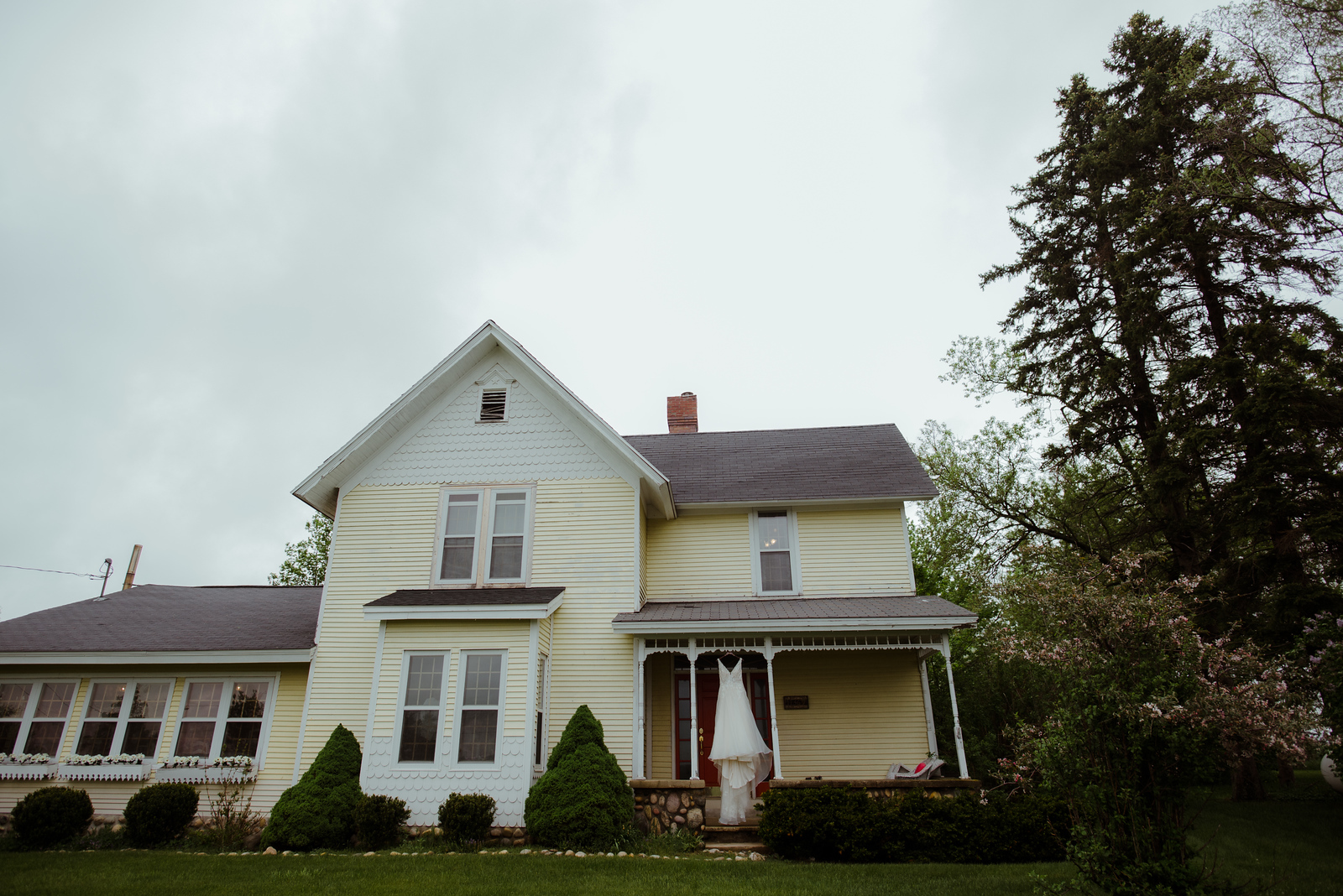 dress hanging from porch on farm house at barn wedding in traverse city michigan