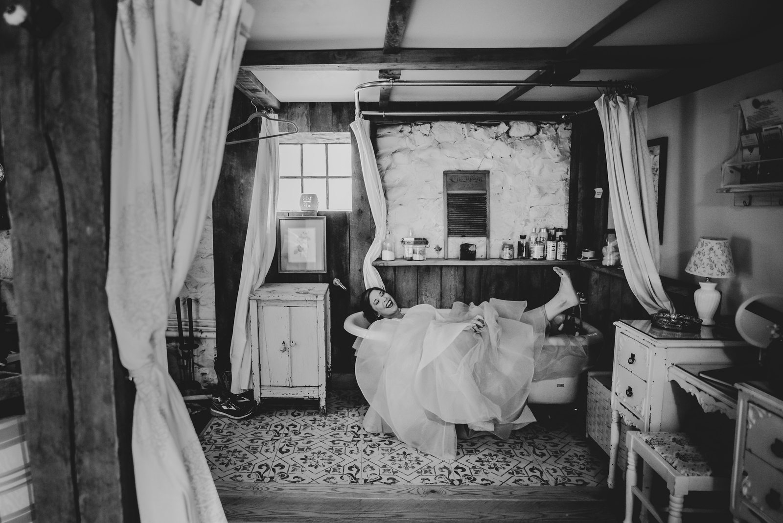 bride candid laying in bath tub in wedding dress in traverse city michigan
