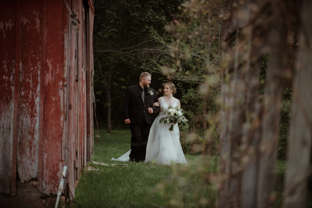 traverse city bride waiting with father to walk down aisle in traverse city barn wedding