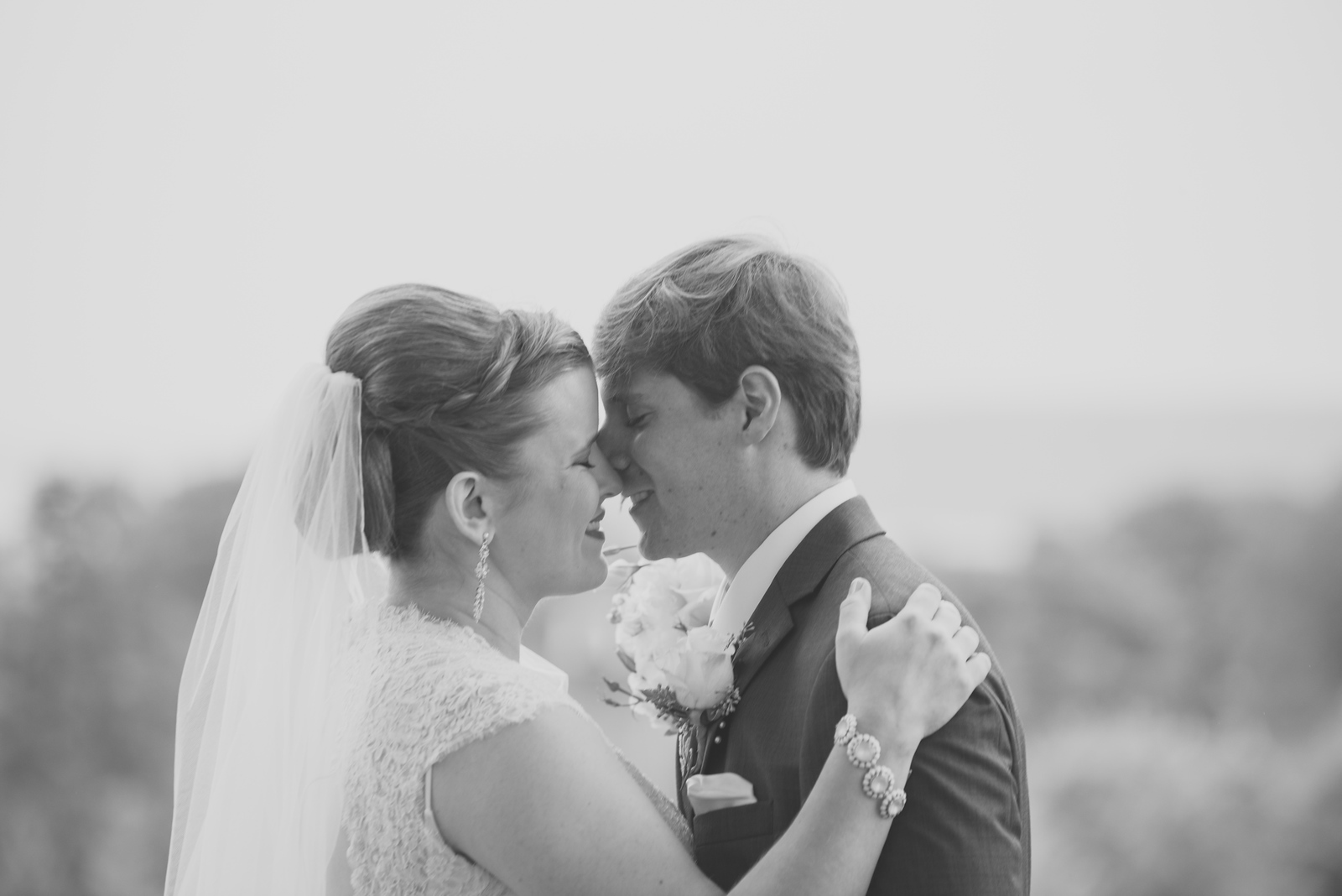 black and white fine art photo of bride and groom cuddling candid