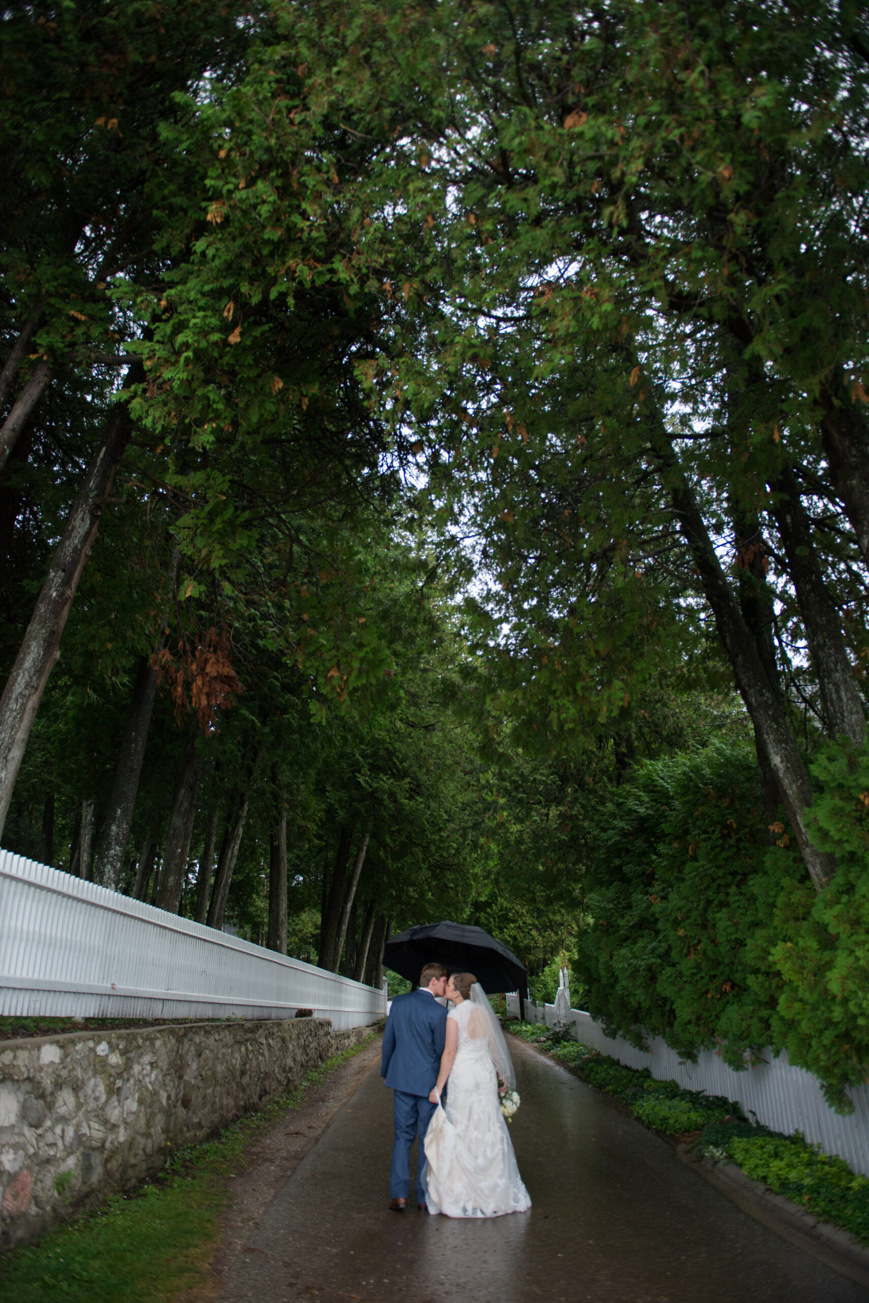 bride and groom walking down mackinac island road in michigan