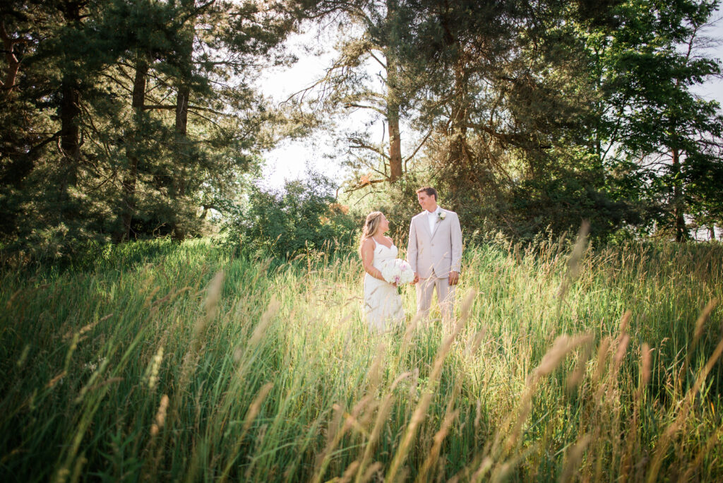 bride and groom standing in field in northern michigan wedding