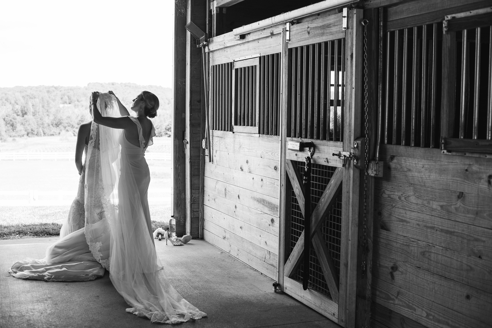 bride and bridesmaid standing inbarnputting on veil at traverse city michigan