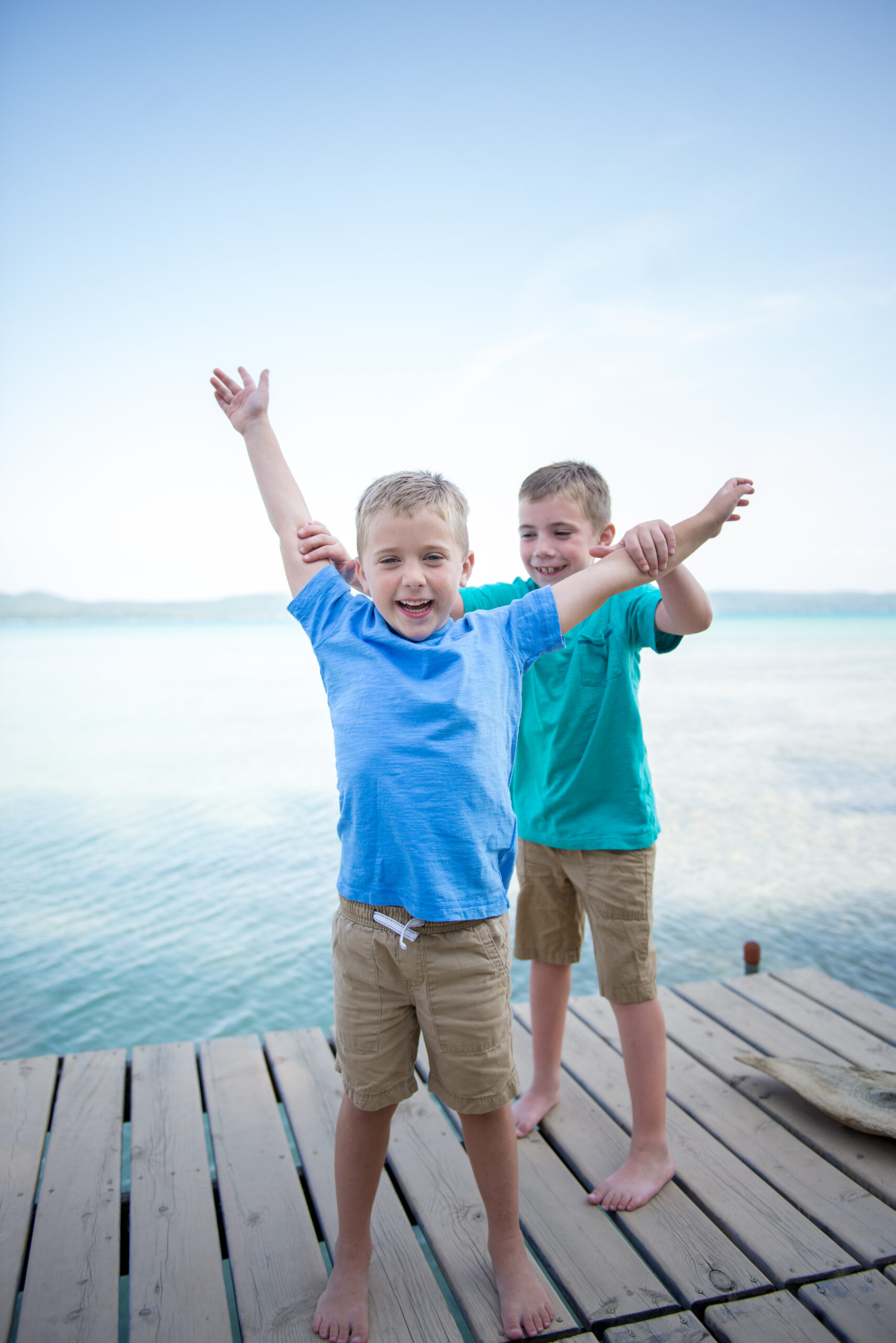 two brothers playing during family pictures in Glen Arbor michigan