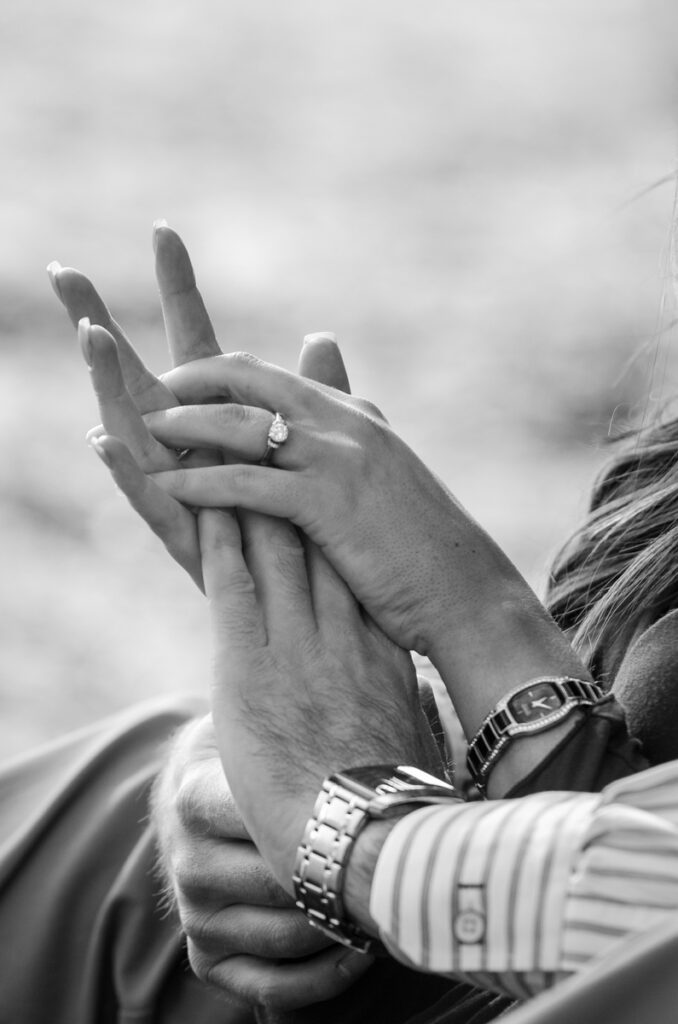 bride and groom holding hands during engagement pictures showing wedding ring in traverse city michigan