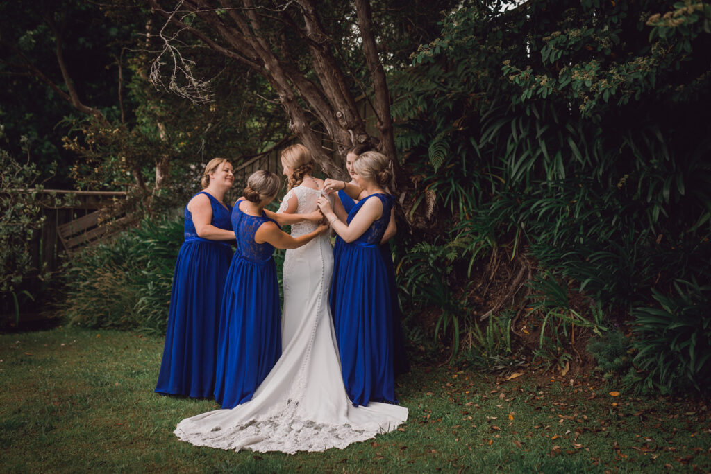 bride surrounded by bridesmaids getting ready for wedding