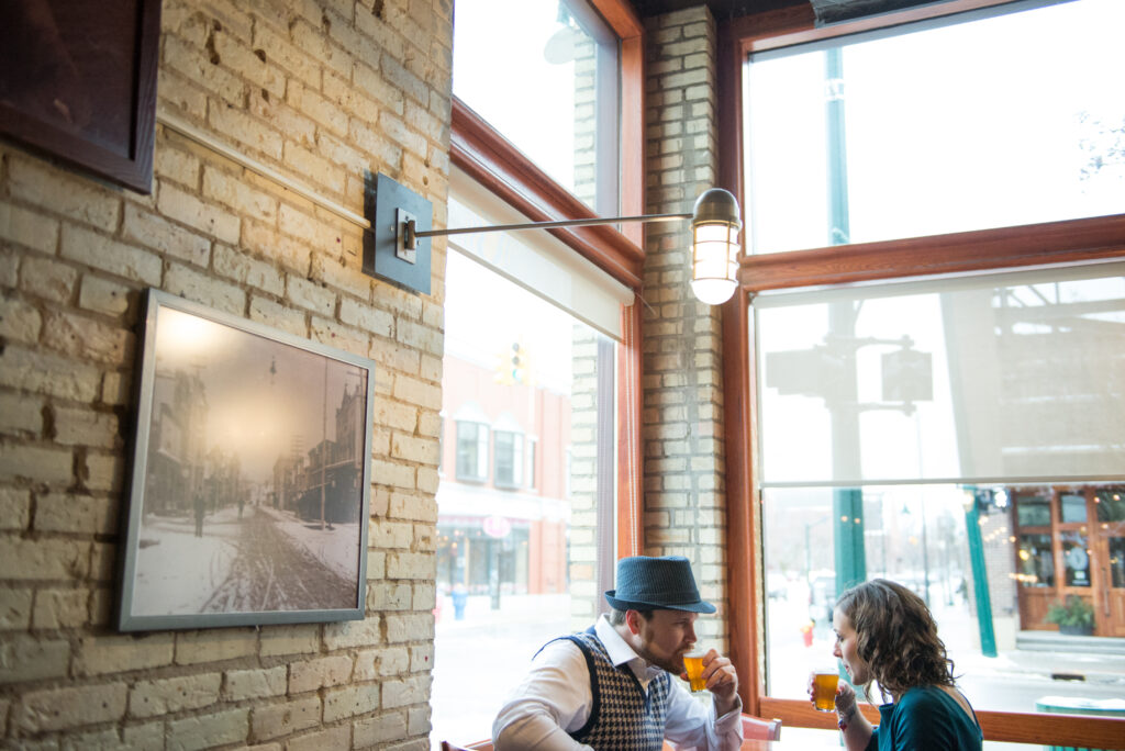 couple pose inside pub downtown traverse city michigan for engagement photos