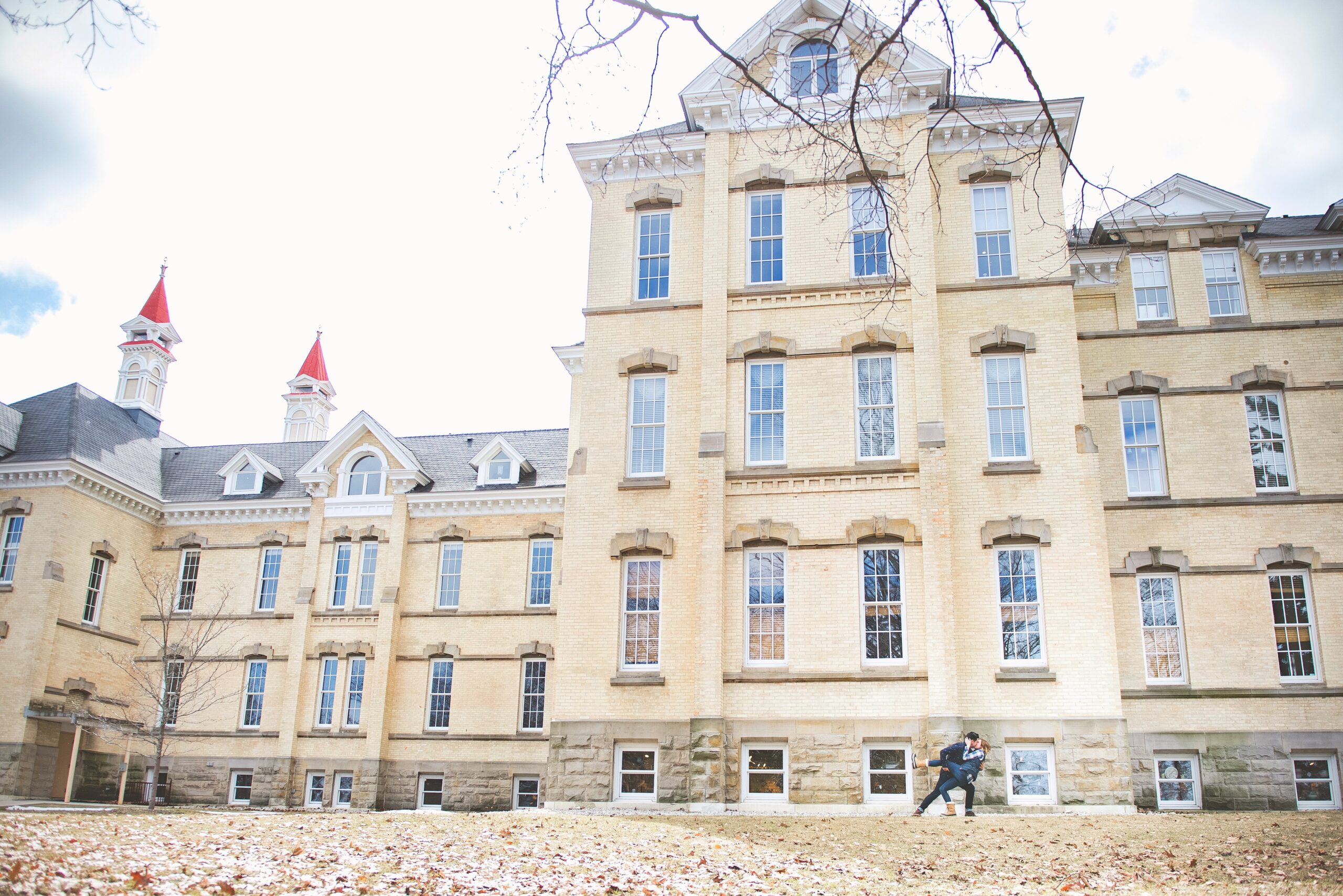 wide photography of michigan couple posing at the grand traverse commons in traverse city
