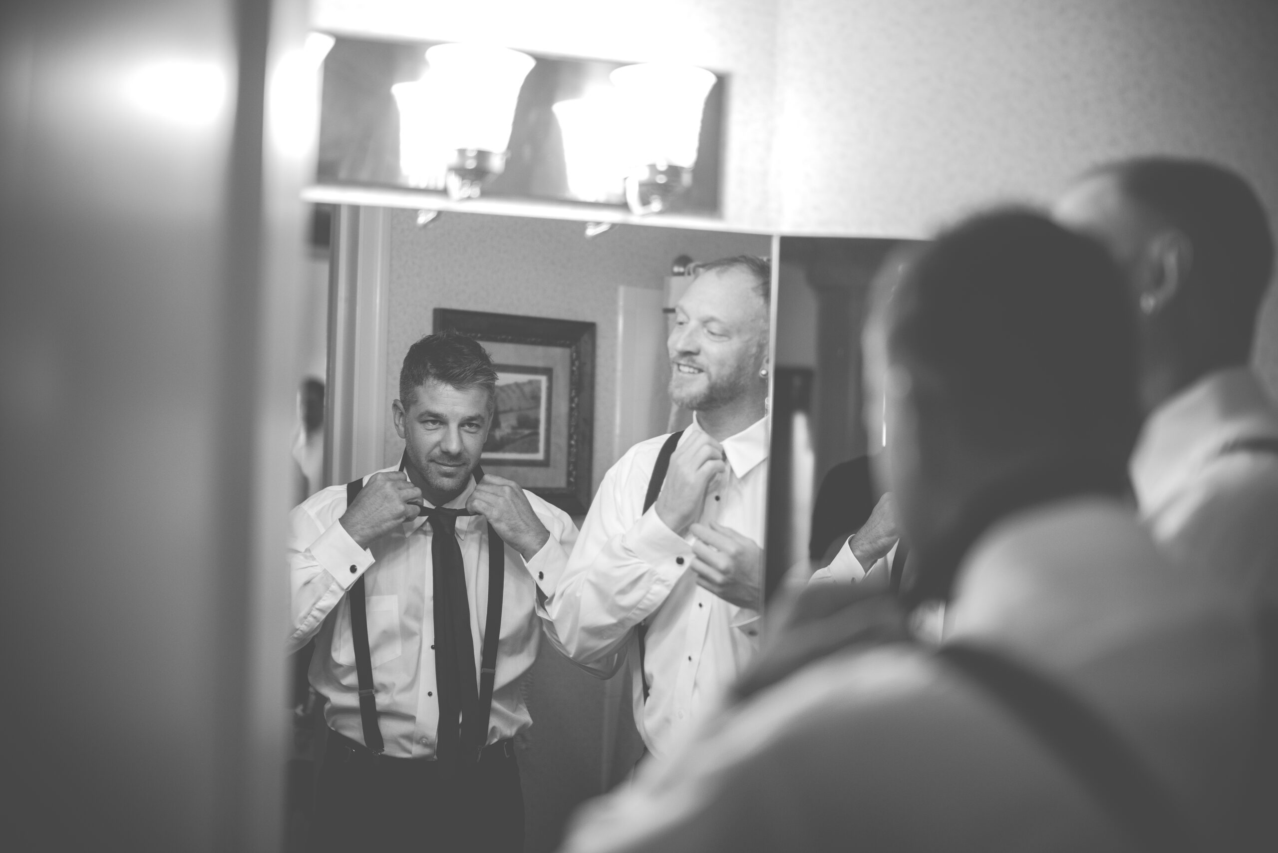 groom getting ready for wedding photography in downtown traverse city michigan