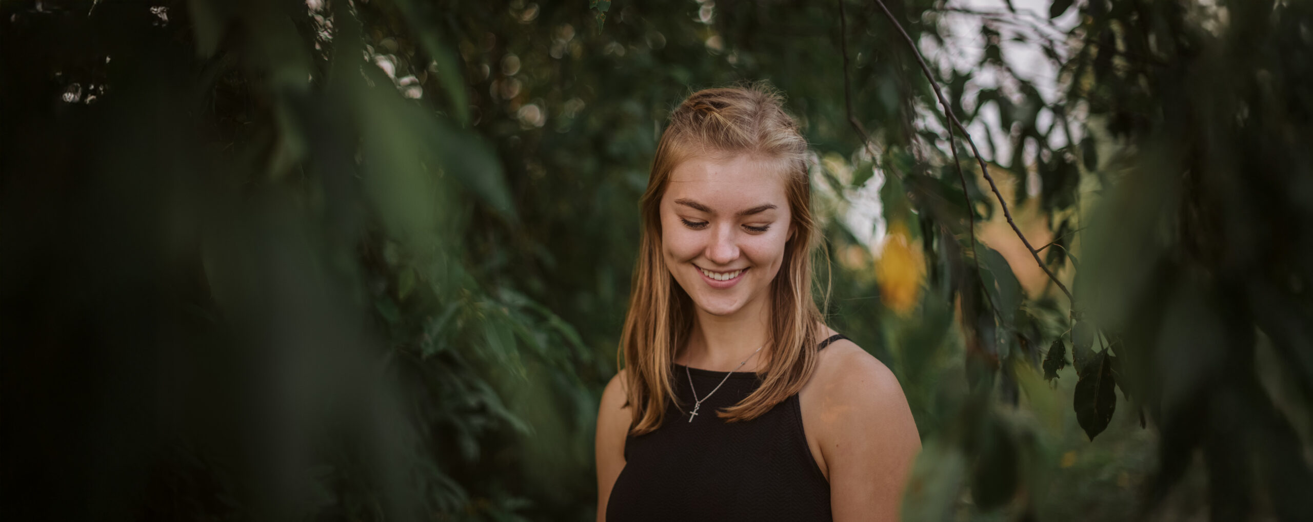 high school senior walking in willow branches in traverse city senior photos