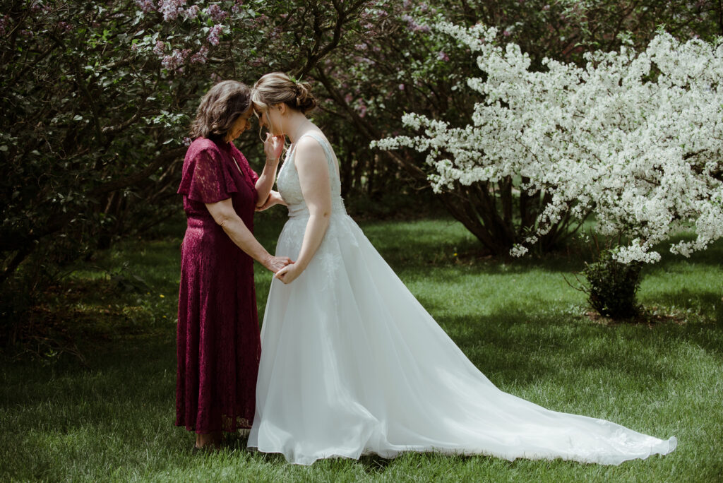 mother-of-bride-crying-candid-wedding-photography-traverse-city bride and mother embracing before wedding ceremony in spring wedding in traverse city michigan