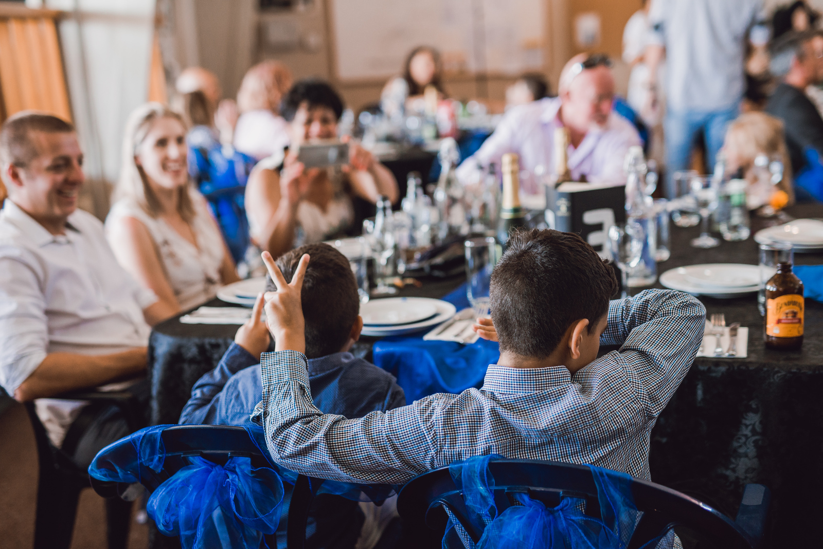 boys sitting at reception making faces in destination wedding