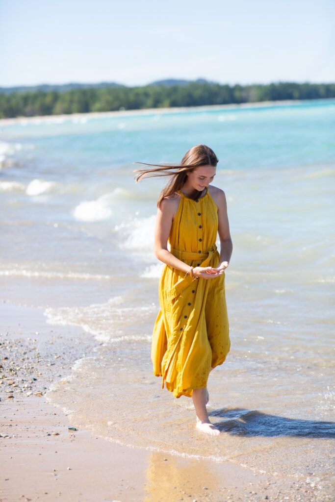 senior-girl-empire-beach-senior-photos girl walking on beach during traverse city senior photos