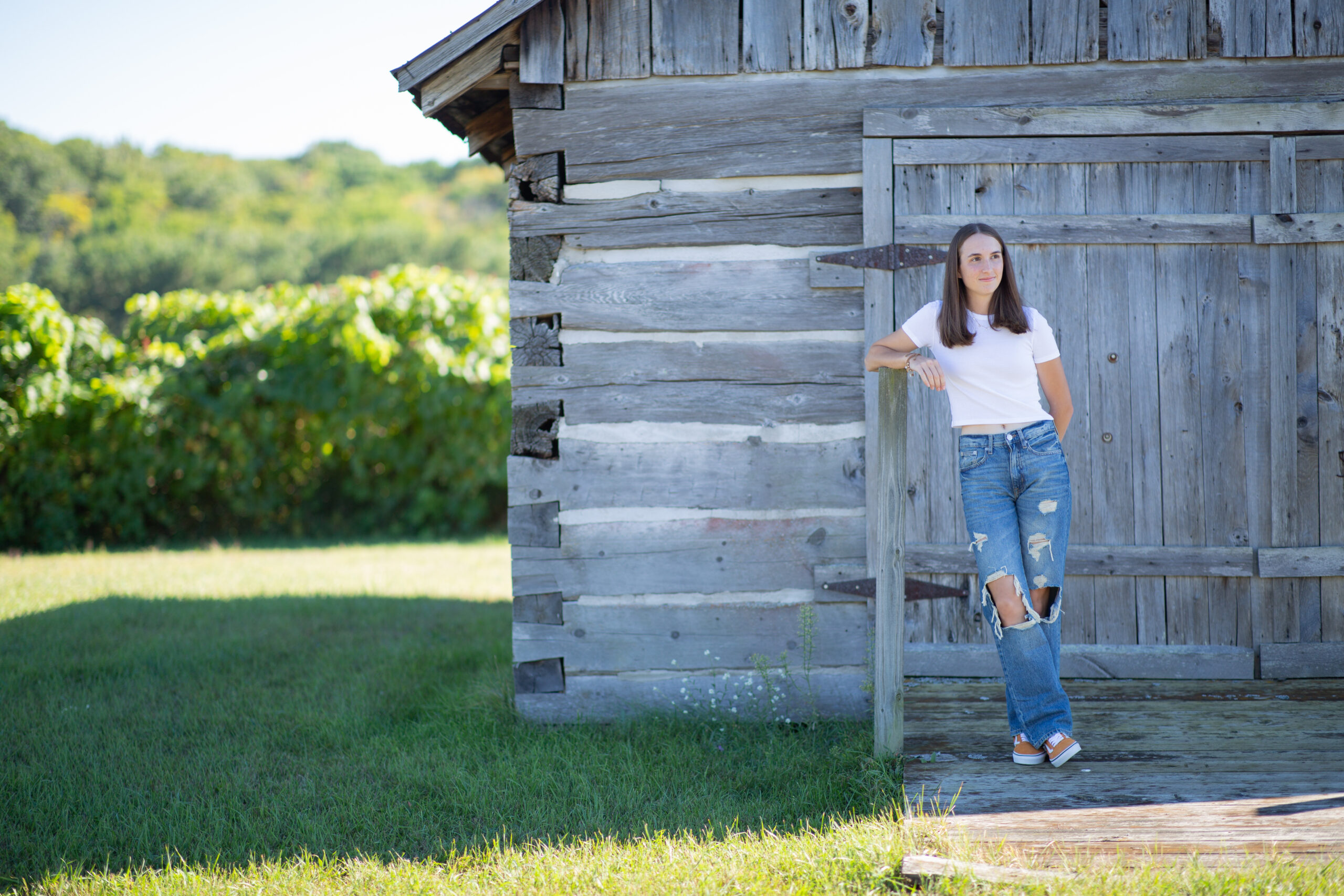 girl walking by barn during Empire Michigan senior photos
