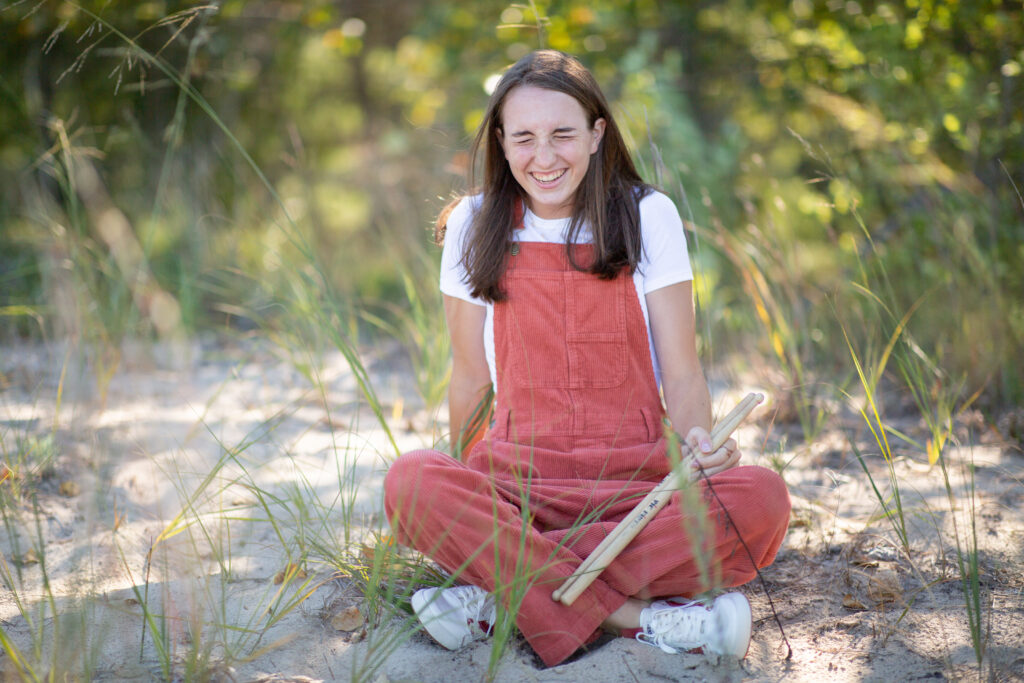 girl walking by barn during Empire Michigan senior photos