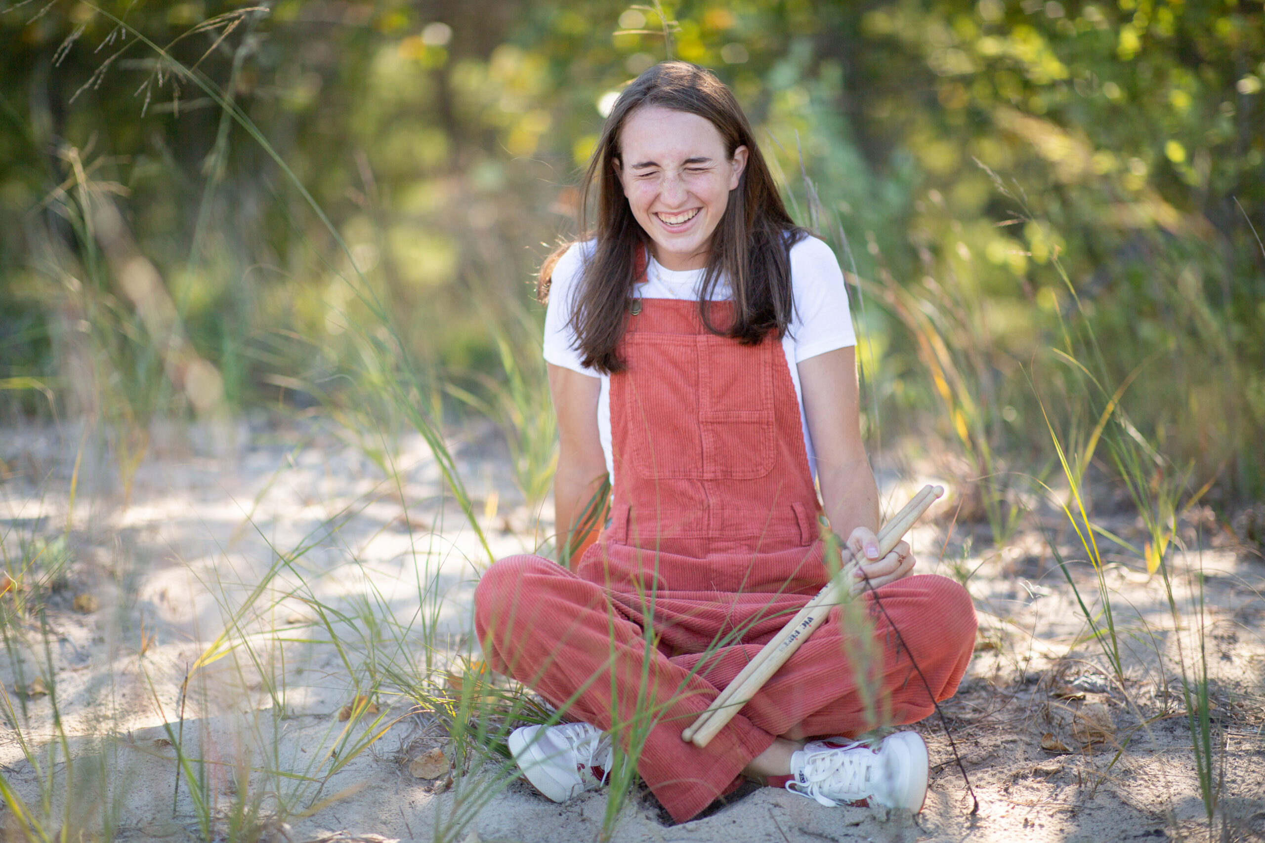 girl walking by barn during Empire Michigan senior photos