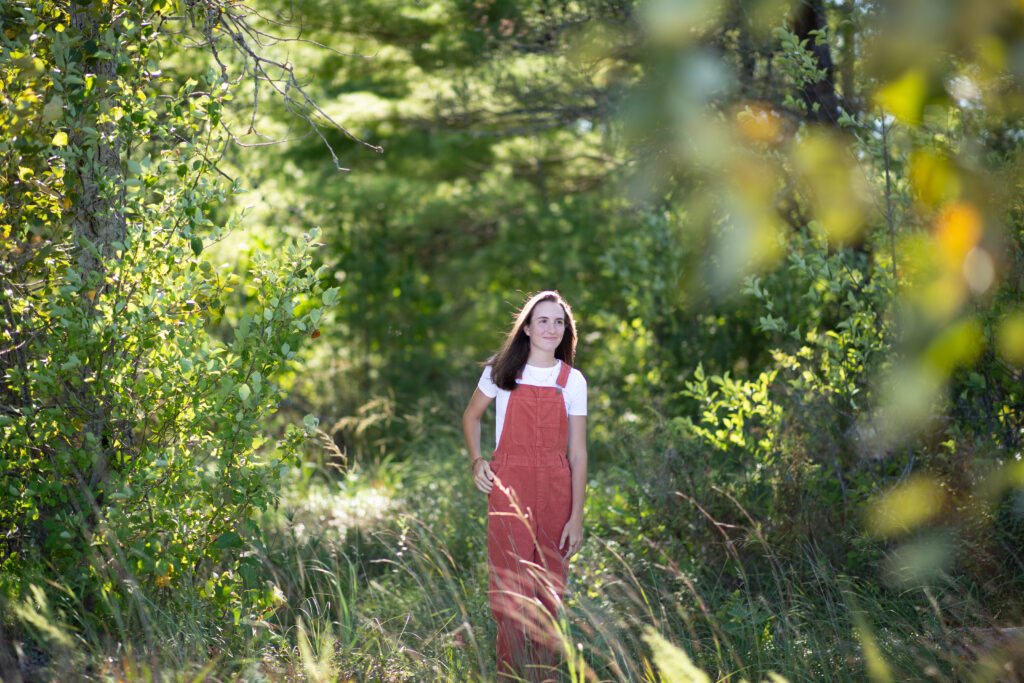 girl walking in woods during traverse city senior photos