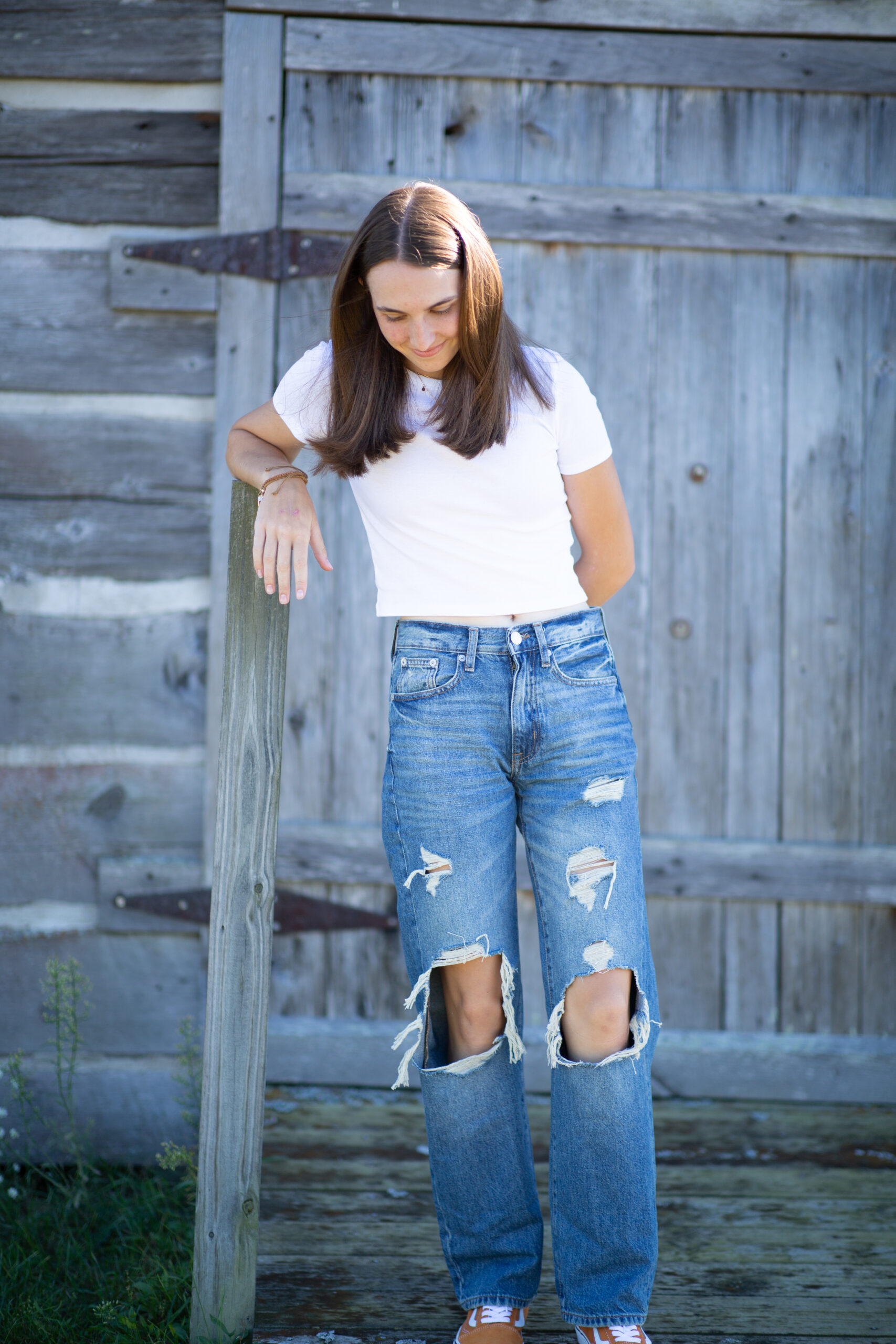 girl walking by barn during Empire Michigan senior photos