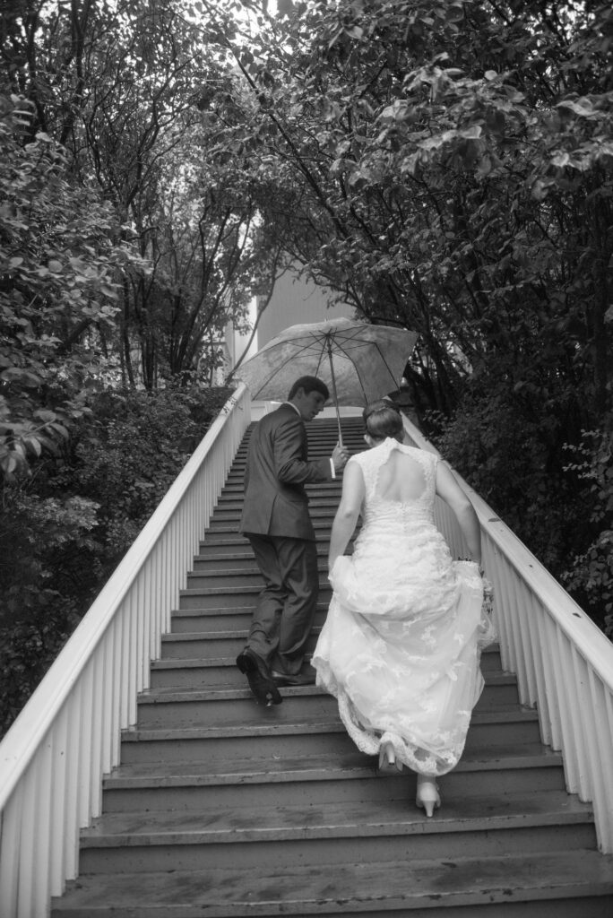 traverse-city-wedding-photographer bride and groom walking on mackinac island in rain Used in Northern Michigan Wedding Guide