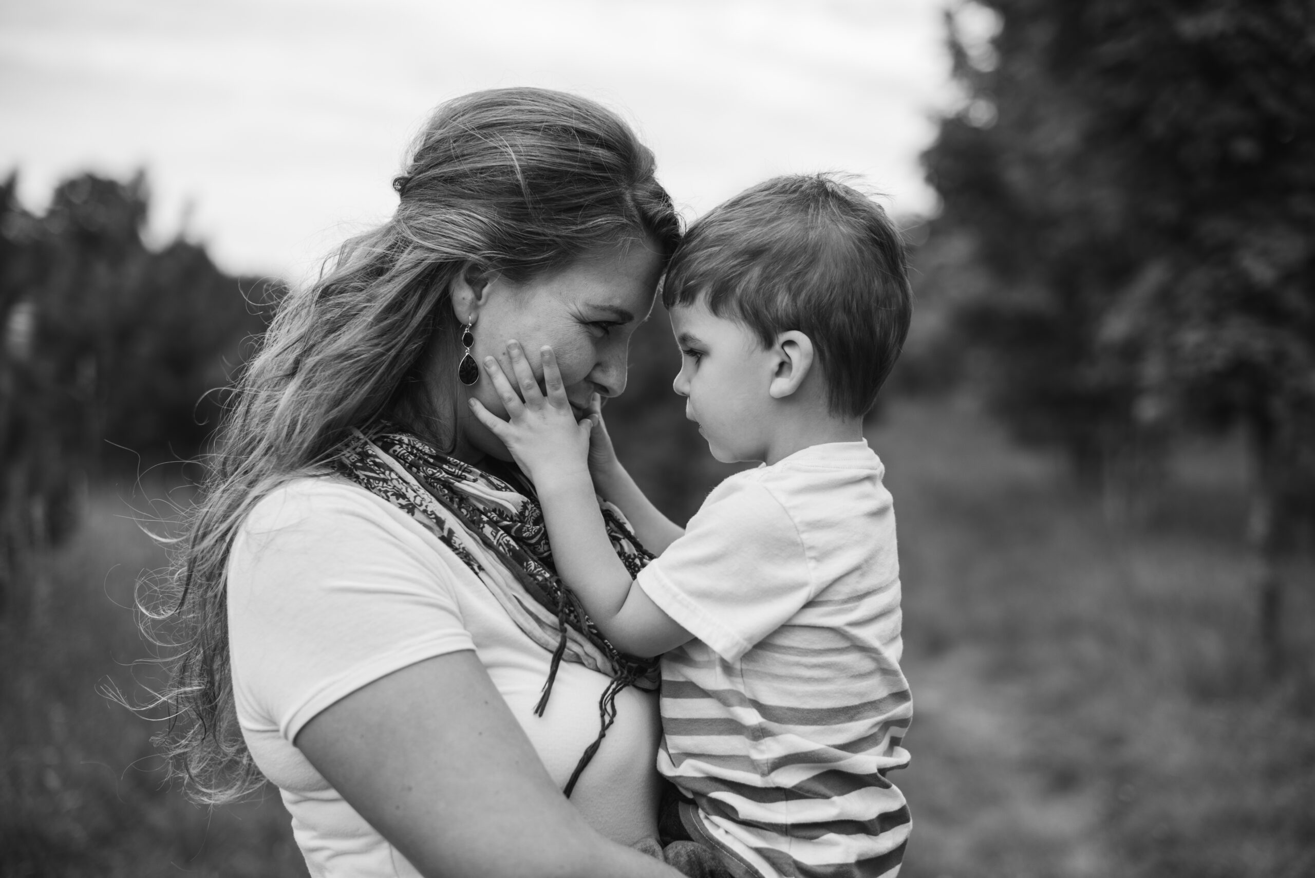 Little boy touching his moms face during family pictures in Traverse city family photographer