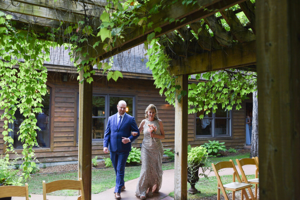 mother of the bride and son walking down aisle at wedding in traverse city michigan wedding photography