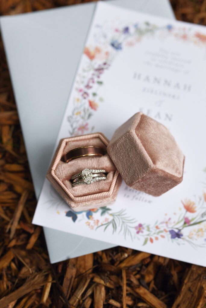 blue-bridge-event-center-Traverse-city-michigan-wedding-37 wedding rings on invitation at blue bridge event center wedding in traverse city michigan Michigan Northern Michigan Wedding Photography