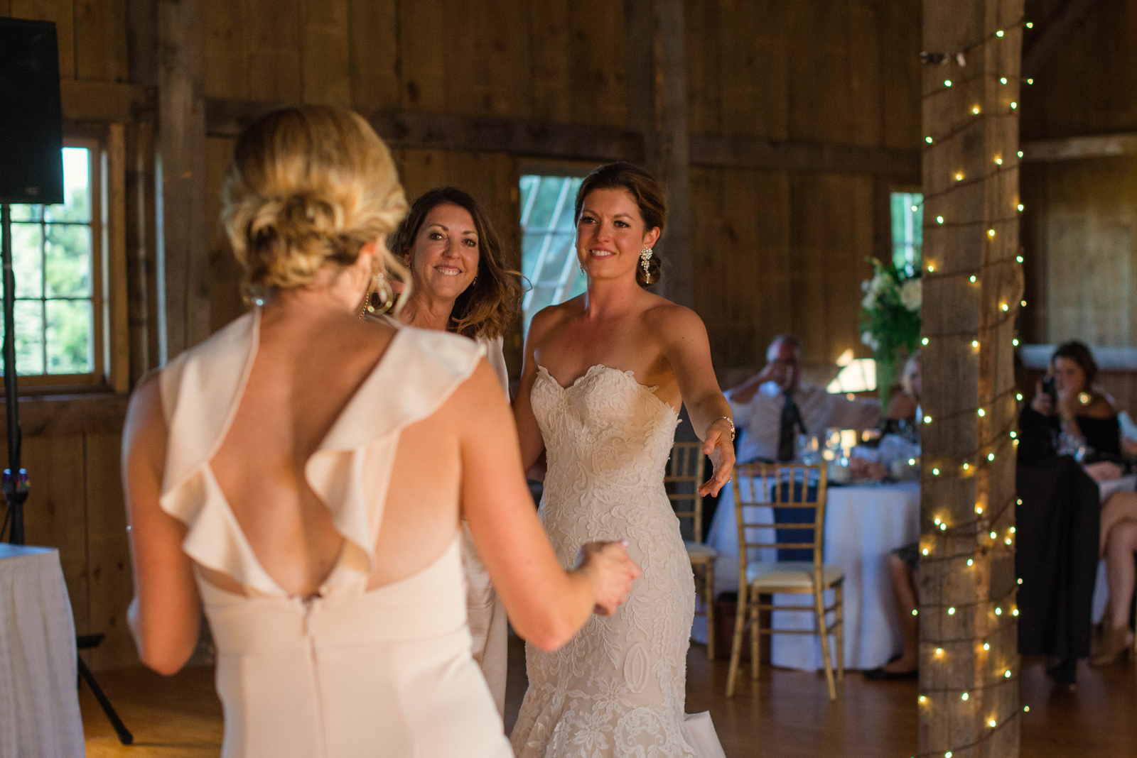 bride and mother motioning to sister to dance at wedding in traverse city