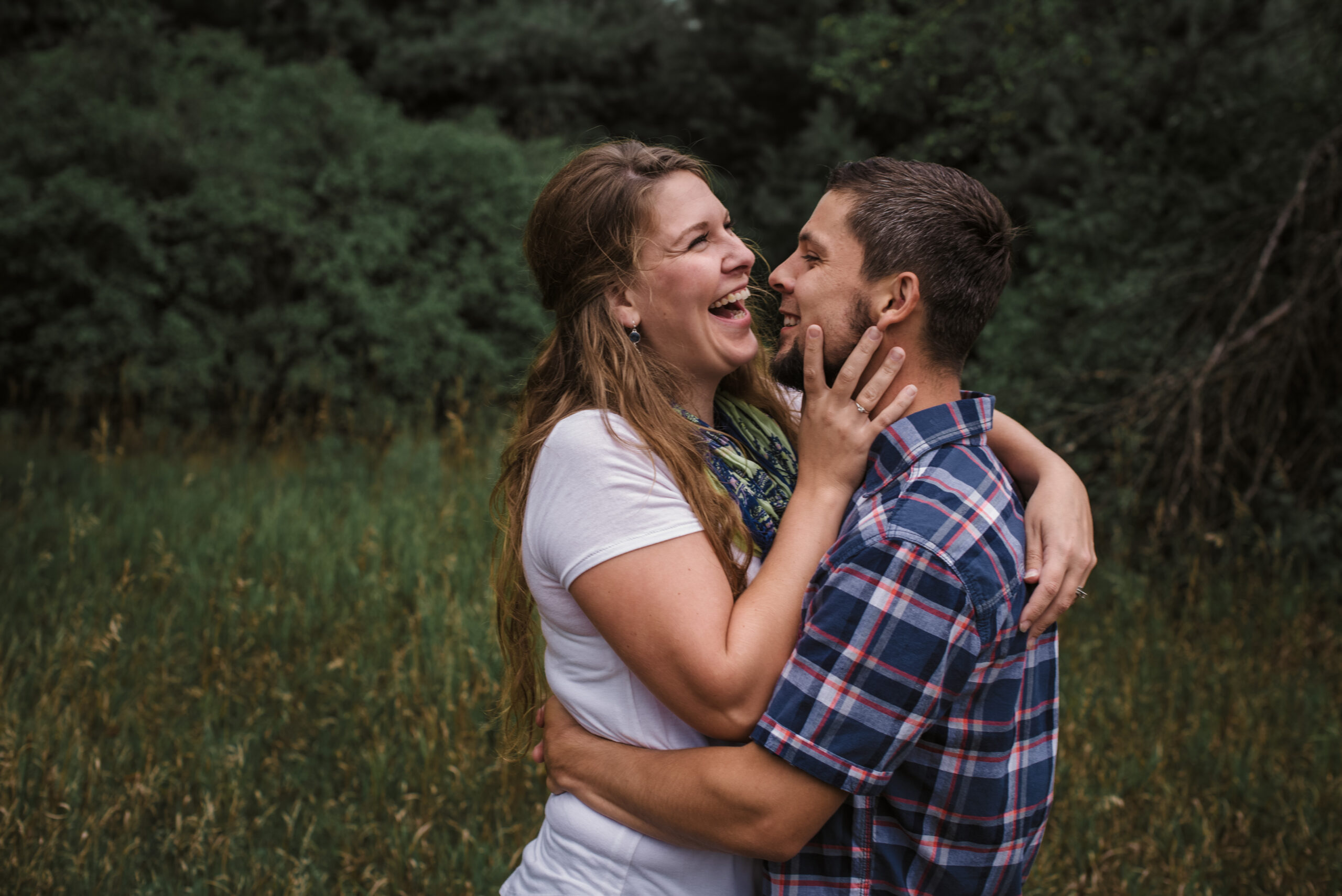 husband and wife laughing during family photos in traverse city michigan