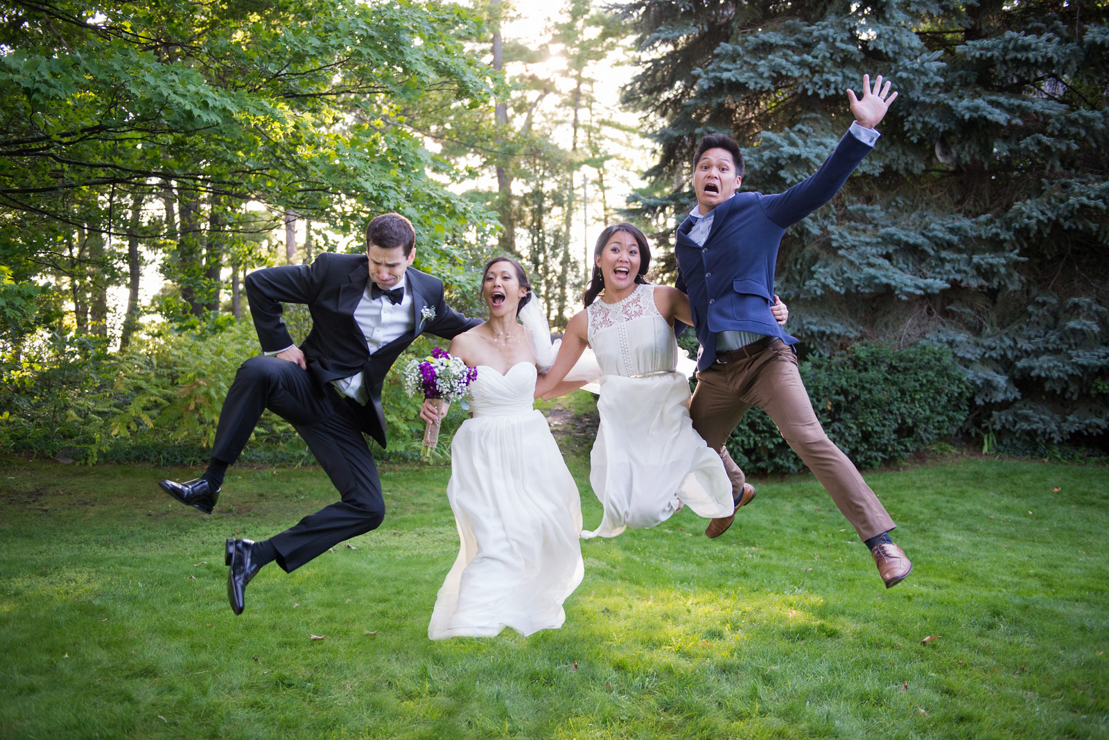 bride and groom jumping with guests at peninsula room in northern michigan wedding photographer