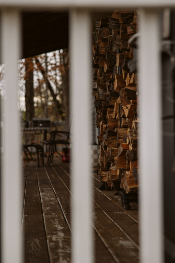 view through the slats of a front porch with split logs during traverse city newborn photos