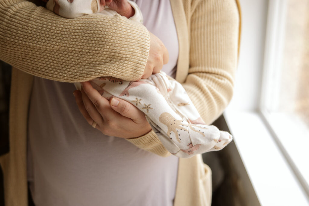 close up of hands holding a newborn baby in traverse city michigan