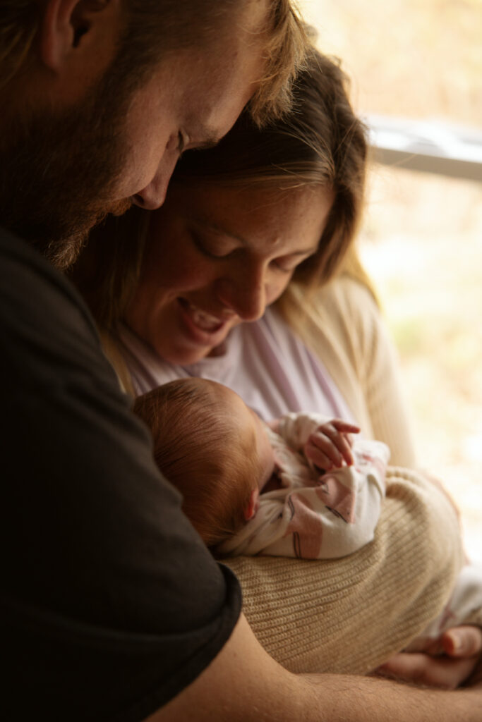 close up of a mother and father holding their baby at a home newborn session in traverse city michigan