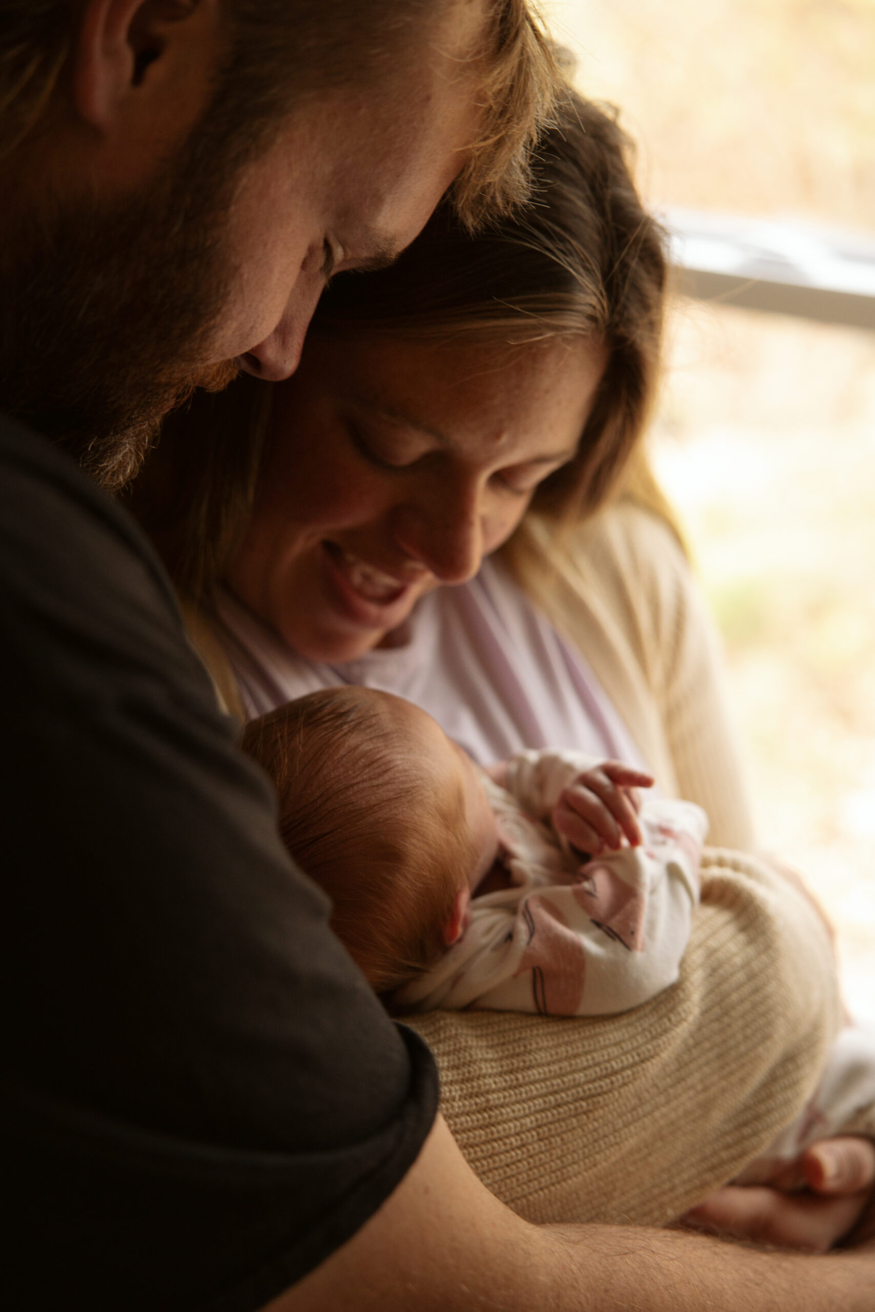 close up of a mother and father holding their baby at a home newborn session in traverse city michigan