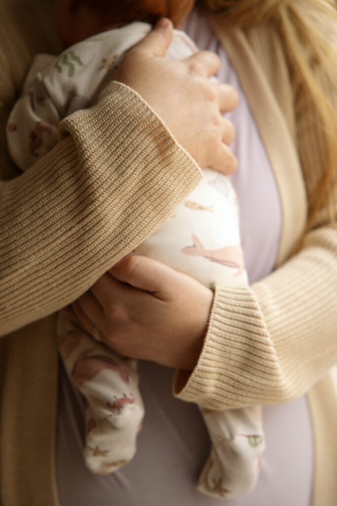 close up of hands holding a newborn baby in traverse city michigan