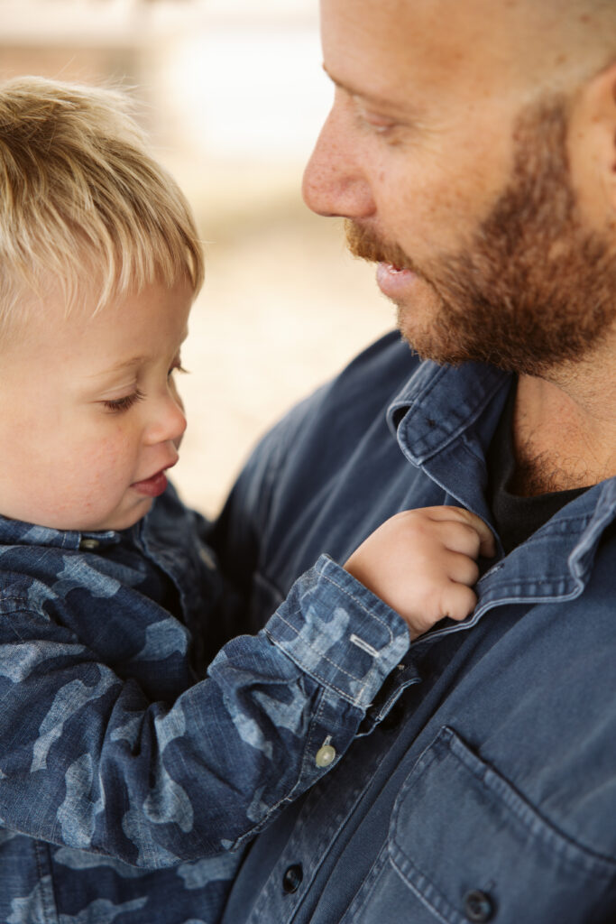 close up of little boys hand on his dads chest during family photos on empire beach. Photo by Lina Lavonne photography a traverse city photographer