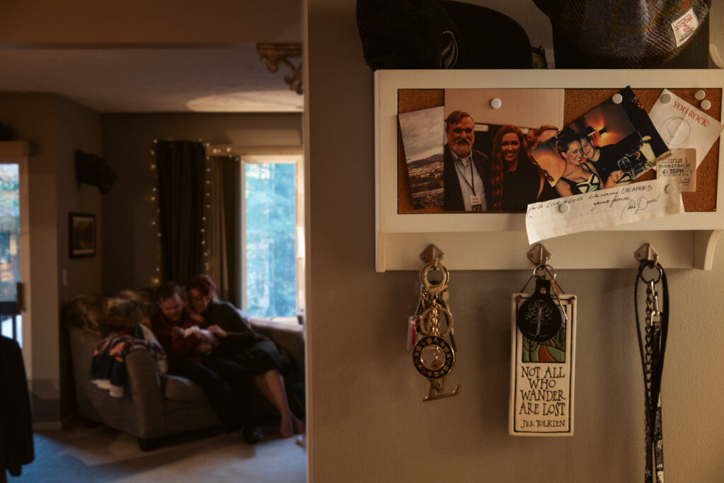 close up of a key hook with pictures while husband and wife hold baby during newborn photos in traverse city. Photo by Traverse City Photographer Lina Lavonne Photography