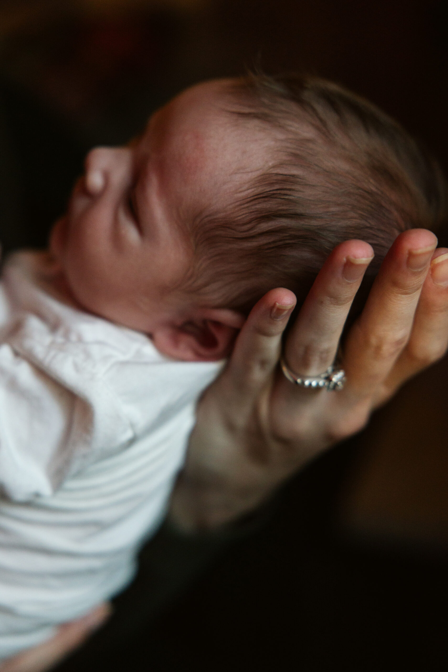 close up of baby in hand of his mother during newborn photos in traverse city. Photo by Traverse City Photographer Lina Lavonne Photography