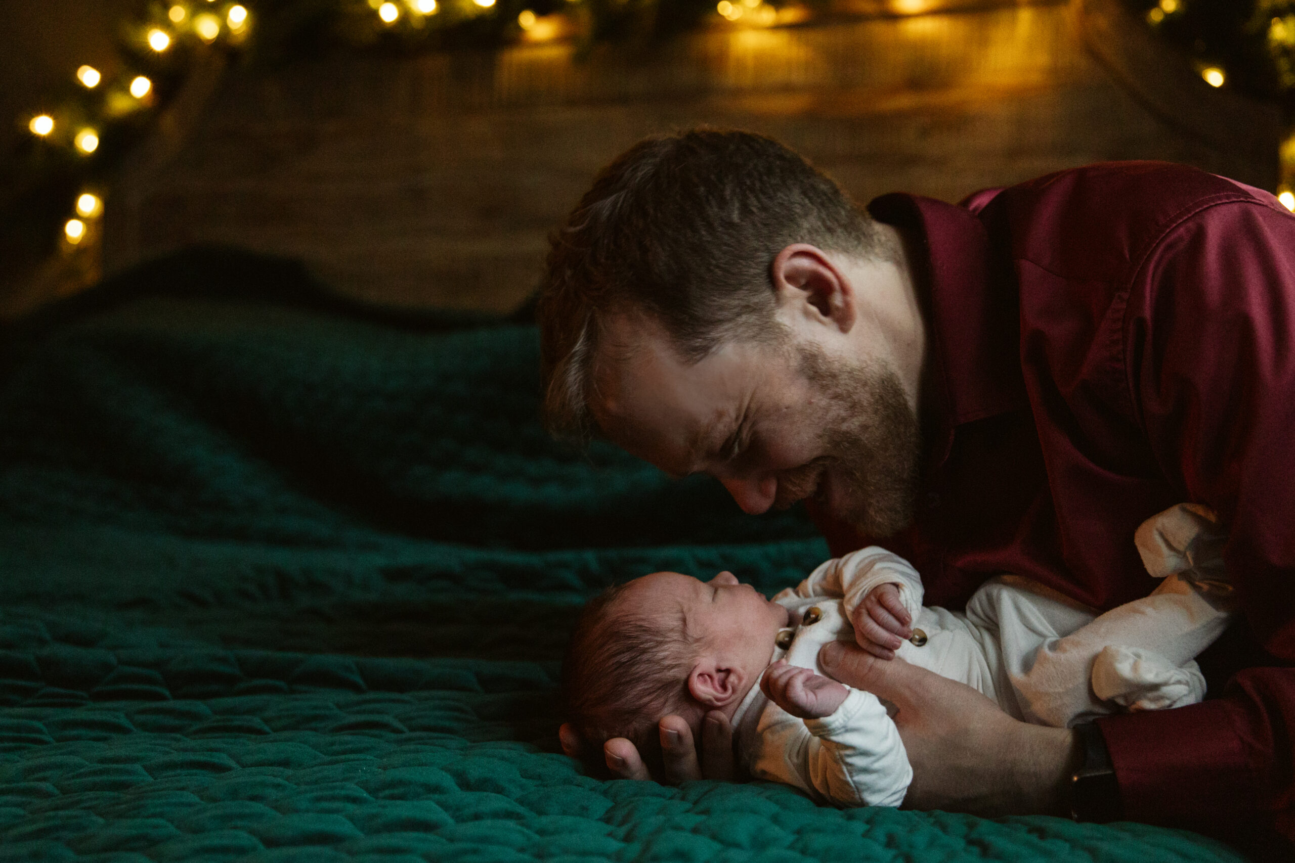 dad holding baby during newborn photos in traverse city. Photo by Traverse City Photographer Lina Lavonne Photography