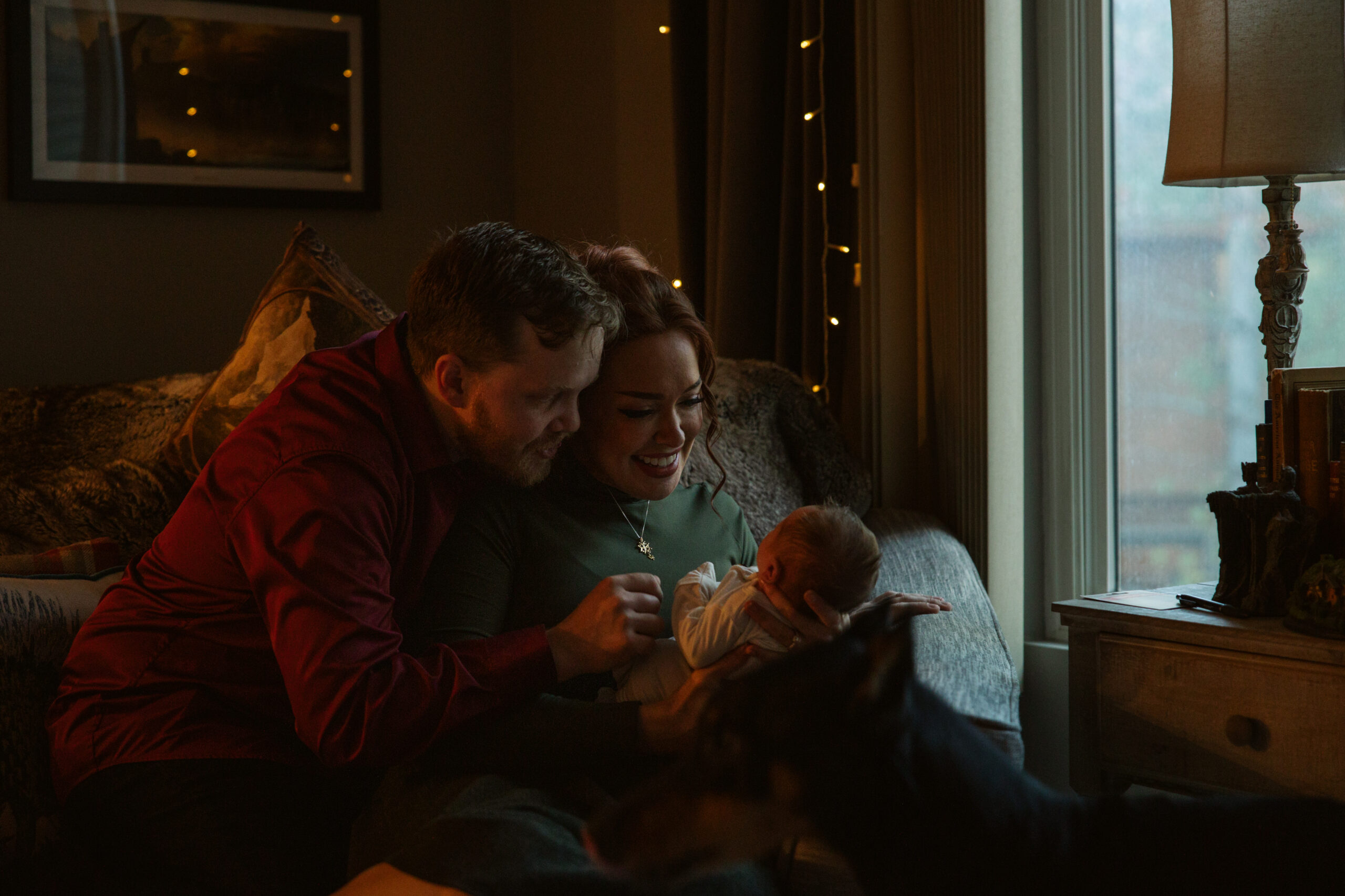 baby in the arms of his mother and father during newborn photos in traverse city. Photo by Traverse City Photographer Lina Lavonne Photography
