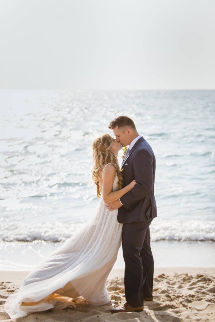 arcadia-bluffs-golf-resort-3 bride and groom kissing on beach in arcadia bluffs wedding